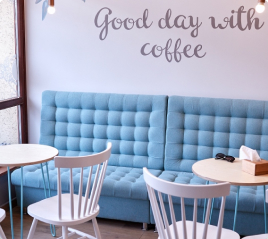 Затишне кафе з блакитними диванами та написом Good day with coffee